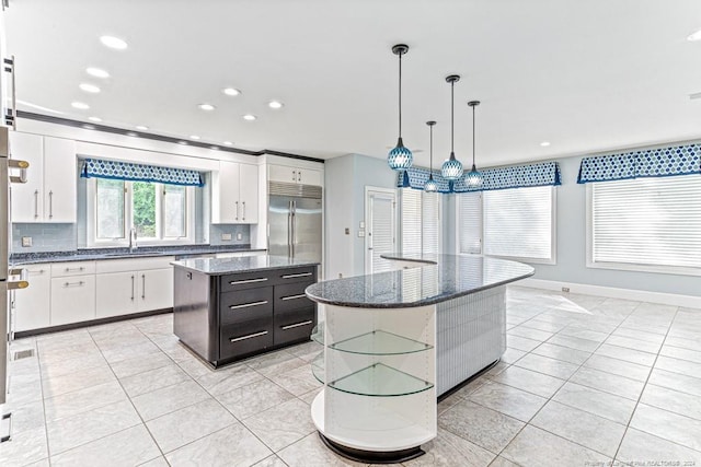 kitchen featuring a sink, white cabinetry, light tile patterned floors, and a kitchen island