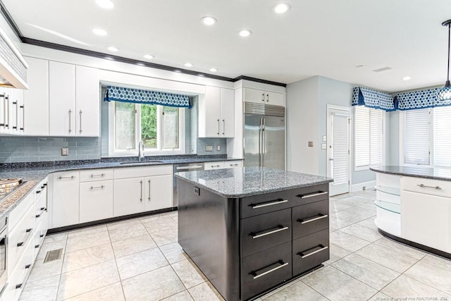 kitchen featuring decorative backsplash, appliances with stainless steel finishes, pendant lighting, and white cabinets