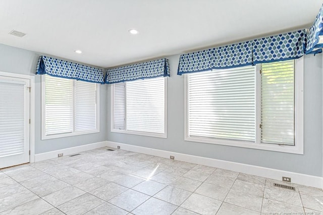 spare room with plenty of natural light, recessed lighting, baseboards, and visible vents
