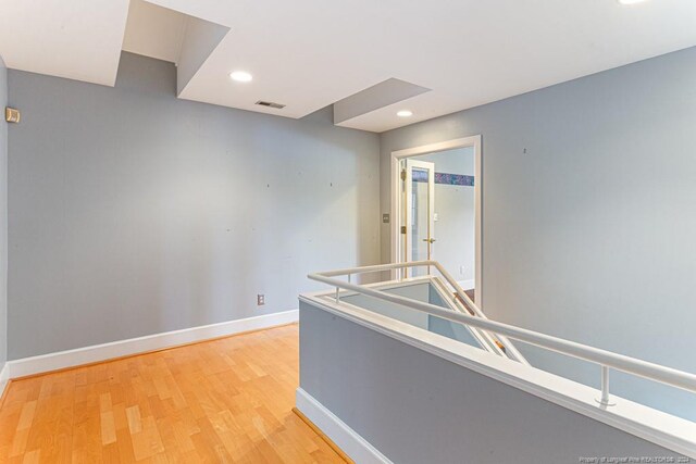 hall with recessed lighting, baseboards, visible vents, and light wood finished floors