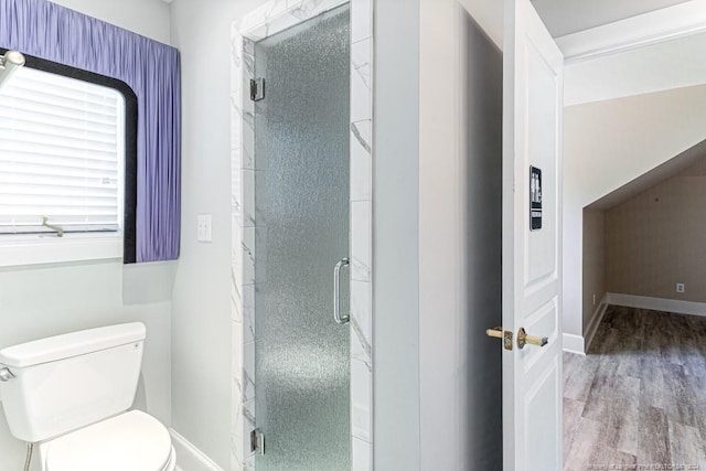 bathroom with hardwood / wood-style flooring, a shower with shower door, and toilet