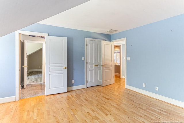 unfurnished bedroom featuring baseboards, visible vents, and light wood-style flooring