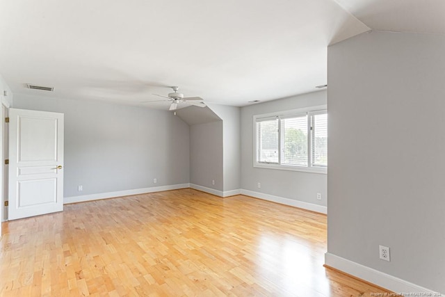 empty room with light hardwood / wood-style floors, lofted ceiling, and ceiling fan