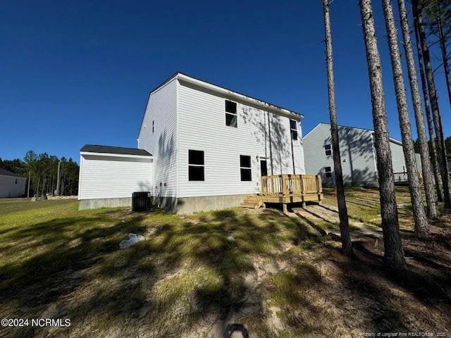 back of property featuring a wooden deck, a yard, and central AC unit