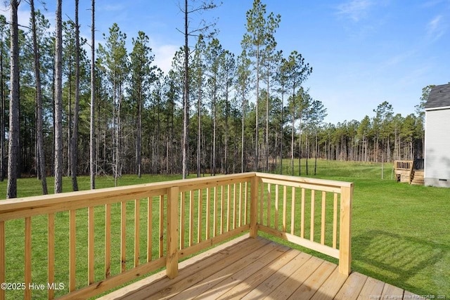 deck featuring a lawn and a forest view