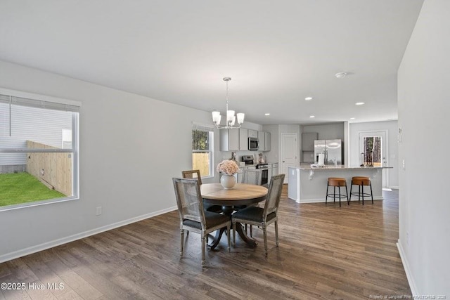 dining space with recessed lighting, baseboards, a notable chandelier, and dark wood-style floors