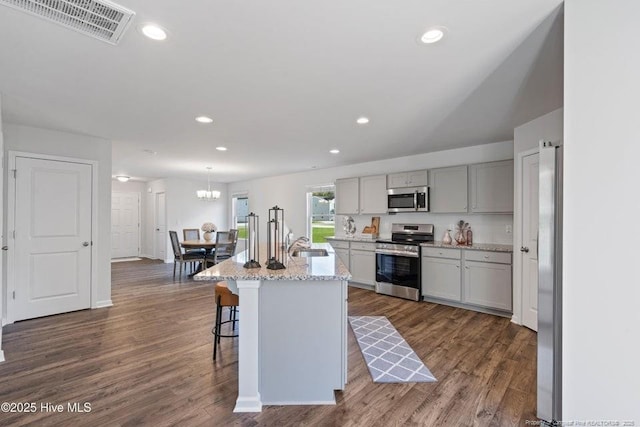 kitchen featuring a sink, stainless steel appliances, dark wood-type flooring, and visible vents