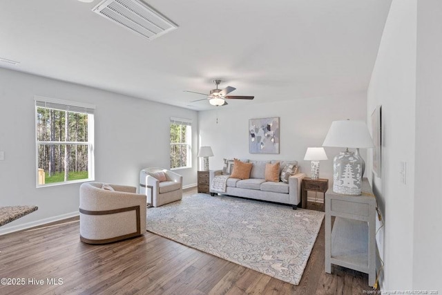 living room with visible vents, a ceiling fan, baseboards, and wood finished floors