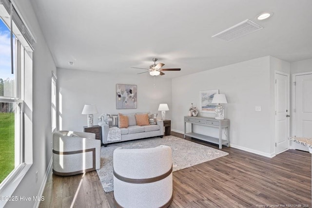 living area featuring a healthy amount of sunlight, visible vents, and dark wood-style flooring