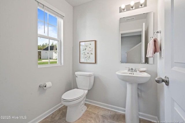 bathroom featuring a sink, baseboards, and toilet