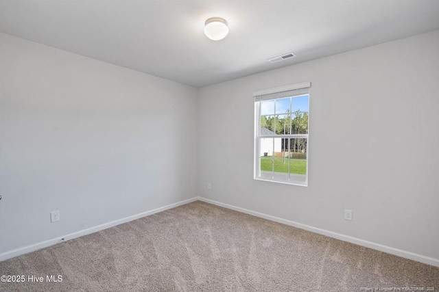 carpeted spare room featuring visible vents and baseboards