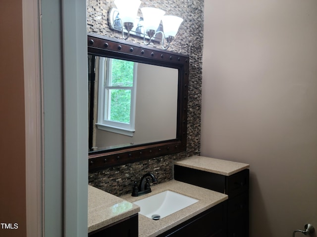 bathroom featuring backsplash, vanity, and a notable chandelier