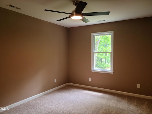 empty room with ceiling fan and carpet