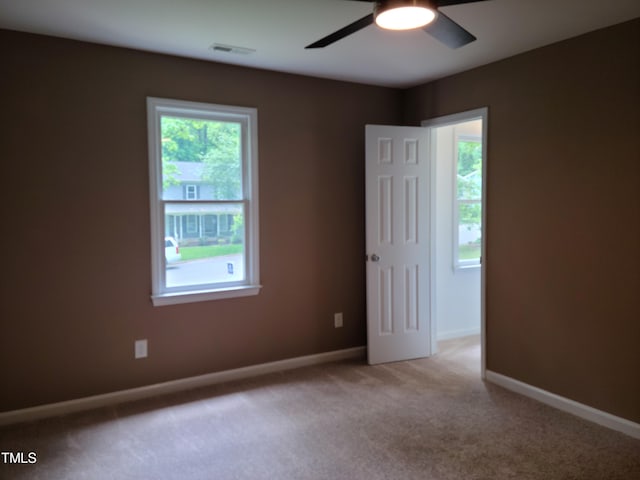 spare room featuring ceiling fan and carpet