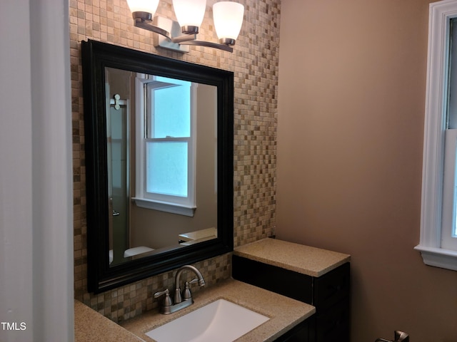 bathroom featuring vanity, backsplash, and a chandelier