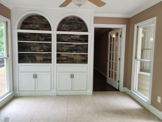 bar with white cabinets, ceiling fan, light tile flooring, and crown molding