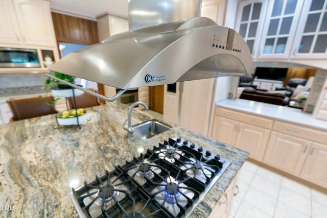 kitchen featuring sink, gas cooktop, wall chimney range hood, and light tile floors