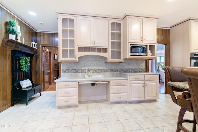 kitchen with appliances with stainless steel finishes, crown molding, custom range hood, tasteful backsplash, and light tile floors