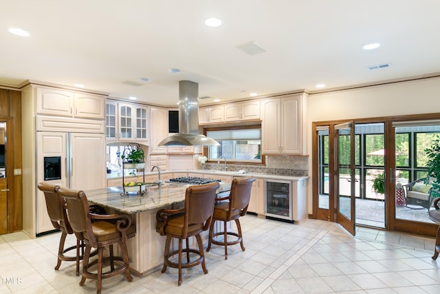 kitchen featuring paneled fridge, tasteful backsplash, wine cooler, a kitchen breakfast bar, and island exhaust hood