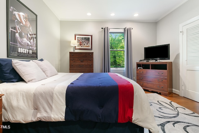 bedroom with hardwood / wood-style floors and crown molding