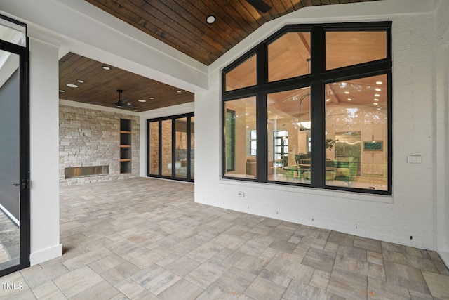 view of patio featuring a fireplace and a ceiling fan