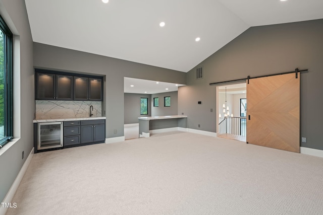 unfurnished living room featuring plenty of natural light, a sink, and visible vents