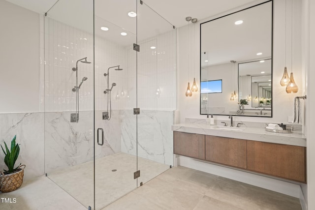 full bathroom with a marble finish shower, vanity, and recessed lighting