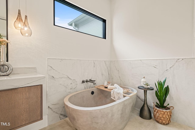 full bath featuring a freestanding bath, tile walls, and tile patterned floors