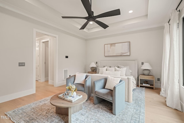 bedroom with baseboards, a tray ceiling, light wood-style flooring, and recessed lighting