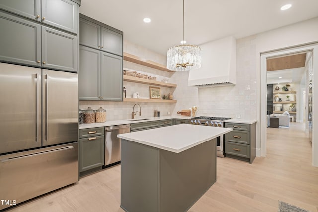 kitchen with stainless steel appliances, premium range hood, a sink, light countertops, and open shelves