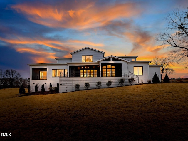 back of house at dusk with a yard