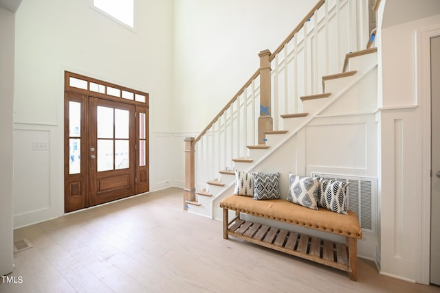 entrance foyer featuring light hardwood / wood-style floors and a towering ceiling