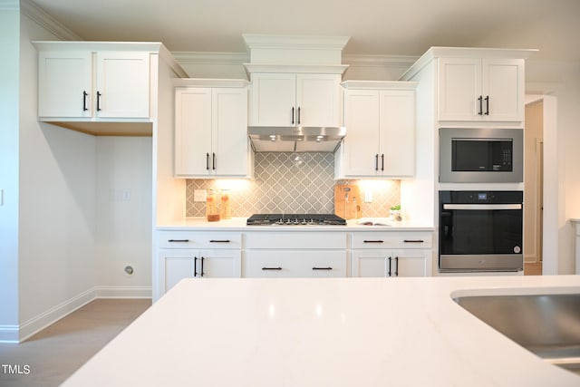 kitchen with light wood-type flooring, appliances with stainless steel finishes, tasteful backsplash, and white cabinets