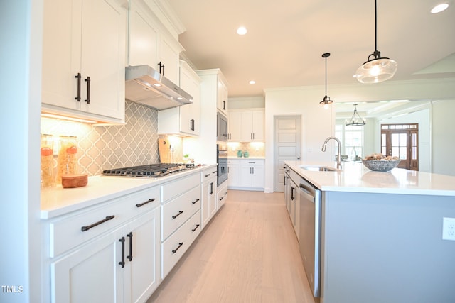 kitchen featuring backsplash, sink, light hardwood / wood-style flooring, white cabinetry, and stainless steel appliances