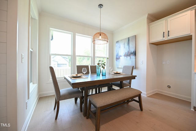 dining space with light hardwood / wood-style flooring and crown molding