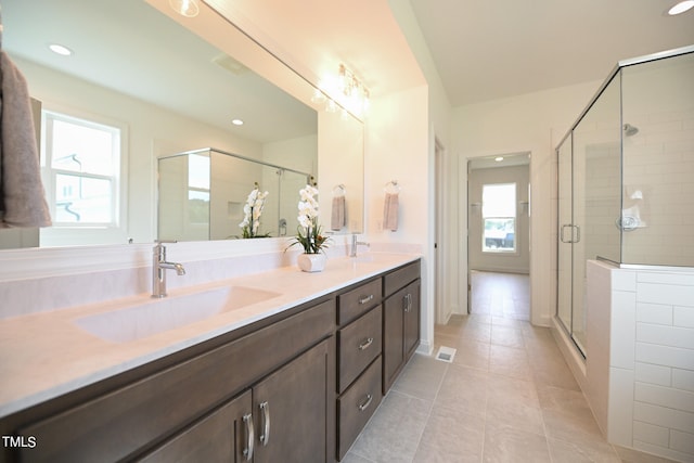 bathroom featuring tile patterned flooring, an enclosed shower, and vanity