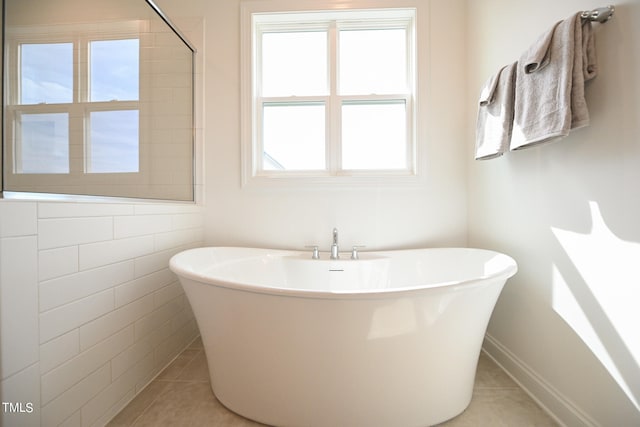 bathroom featuring plenty of natural light, a tub, and tile patterned floors