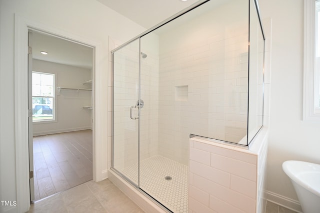 bathroom featuring plus walk in shower and hardwood / wood-style flooring