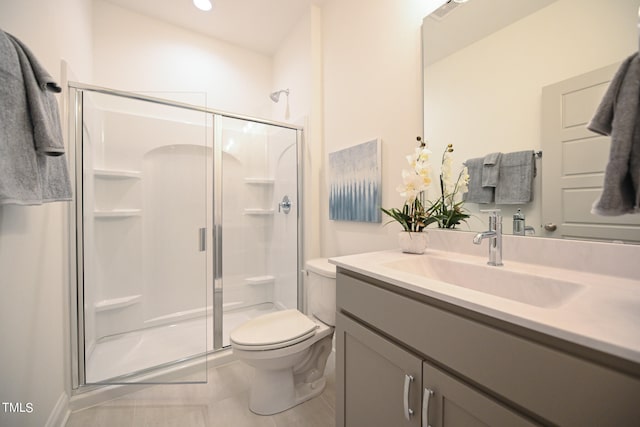 bathroom featuring toilet, tile patterned flooring, vanity, and a shower with shower door