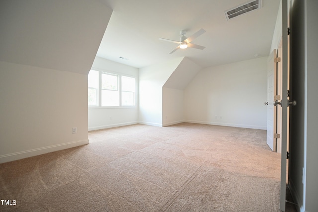 additional living space featuring ceiling fan, vaulted ceiling, and light colored carpet