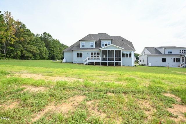 back of property featuring a sunroom and a yard