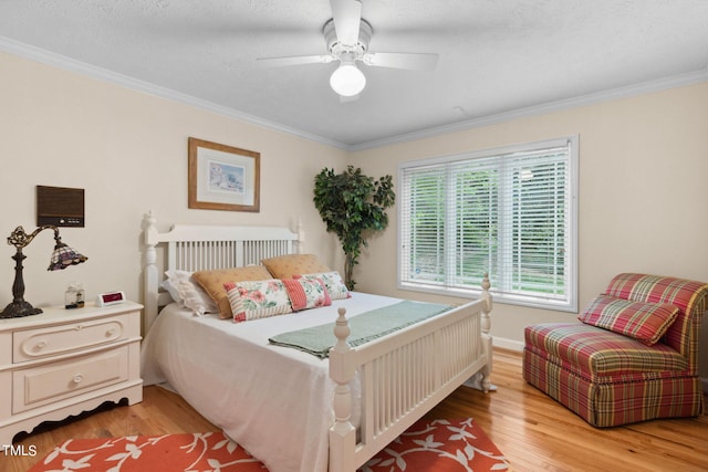 bedroom featuring ceiling fan, light hardwood / wood-style floors, and ornamental molding