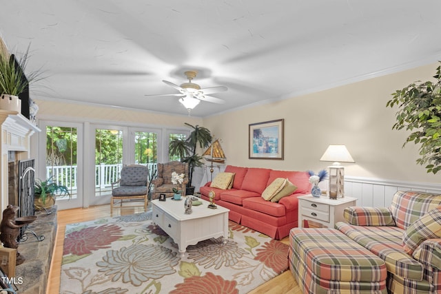 living room featuring light hardwood / wood-style flooring, ceiling fan, and ornamental molding