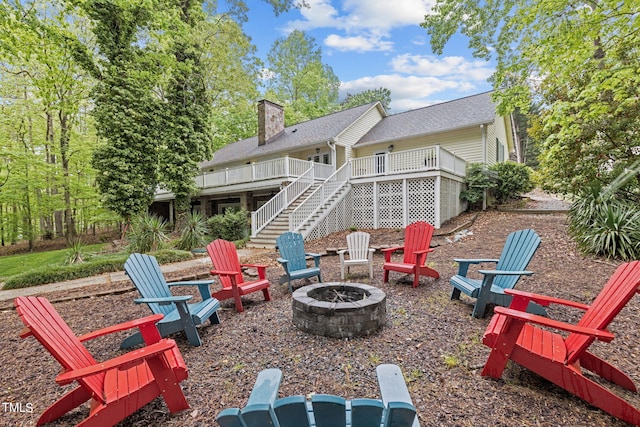 back of house featuring a wooden deck and a fire pit