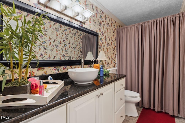 bathroom with dual sinks, oversized vanity, toilet, and a textured ceiling