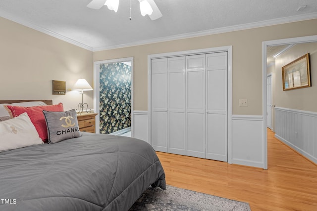 bedroom featuring a closet, crown molding, hardwood / wood-style flooring, ceiling fan, and a textured ceiling