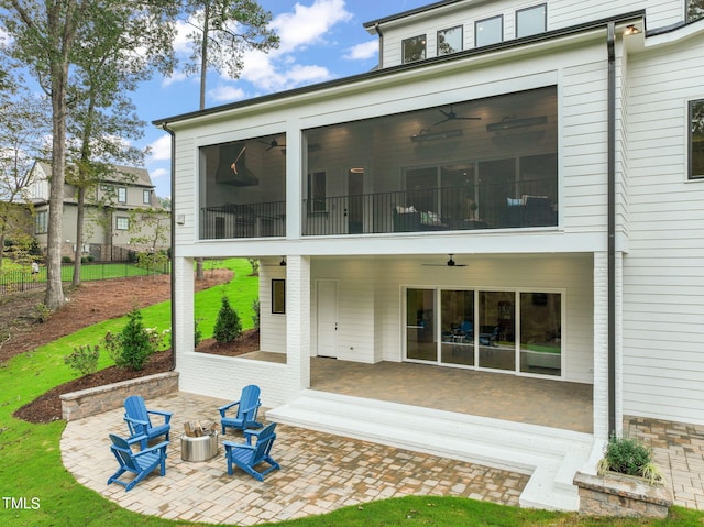 back of house featuring ceiling fan, a patio area, and a fire pit