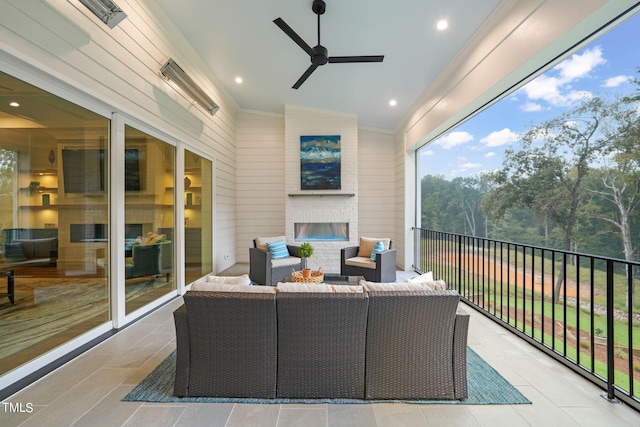 sunroom featuring lofted ceiling, a fireplace, and ceiling fan