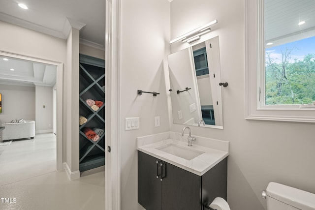 bathroom with ornamental molding, vanity, and toilet