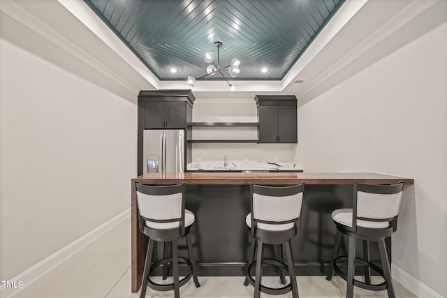 kitchen featuring a breakfast bar, a chandelier, stainless steel fridge with ice dispenser, crown molding, and wooden ceiling